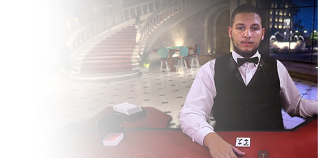 A Ninja Casino live dealer standing behind a blackjack VIP table